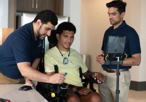 Kinemo co-founders Nordine Sebkhi and Arpan Bhavsar work with Wendell Odom during an assistive technology session using the Kinemo device to support independent computer and device control.
